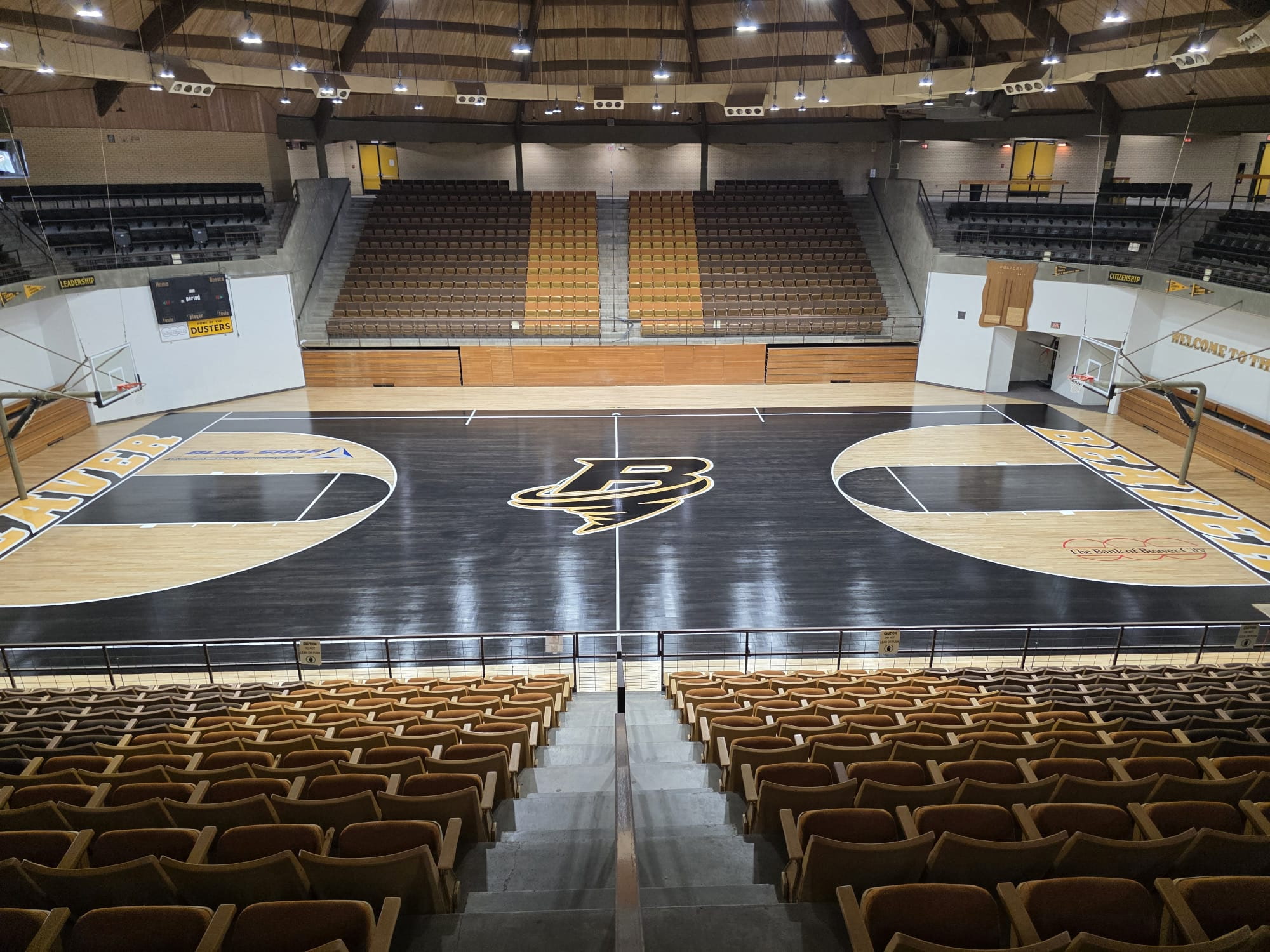 Indoor basketball court with custom wood flooring, basketball goals, and spectator seating
