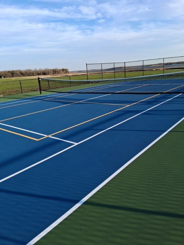 Outdoor tennis court with additional game lines and perimeter fencing